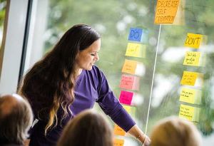 Professional Scrum Master zwei Trainerin bei der Erläuterung von Scrum Techniken