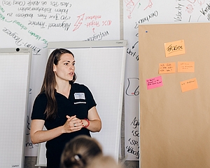 Alisa Stolze erklärt Scrum im Scruminc Workshop. Nebern Ihr ein Produckt Backlog mit Post Its